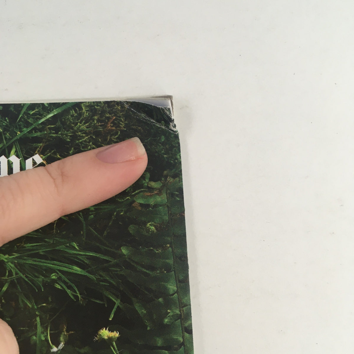 Close-up detail of the cover of The New York Times Magazine, November 12, 2017, 'Life After Driving', highlighting minor wear with a finger pointing to the top edge of the magazine.