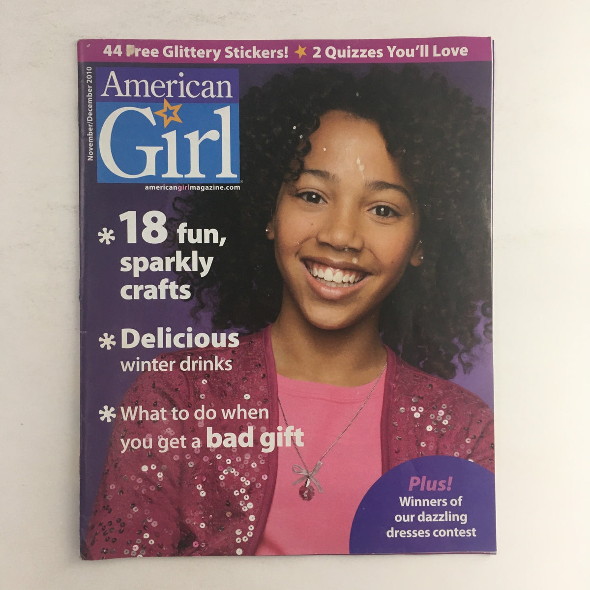 Cover of American Girl Magazine November 2010 featuring the title 'American Girl', highlighting '18 fun, sparkly crafts' and 'Delicious winter drinks'. The cover displays a girl with curly hair smiling, along with promotional text about quizzes and contests.