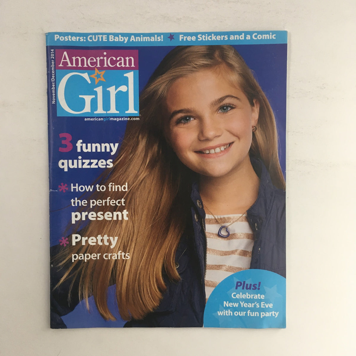 Cover of American Girl Magazine November 2014 featuring a young girl with long blonde hair smiling, highlighting the article 'How to Find the Perfect Present' alongside fun quizzes and crafts.