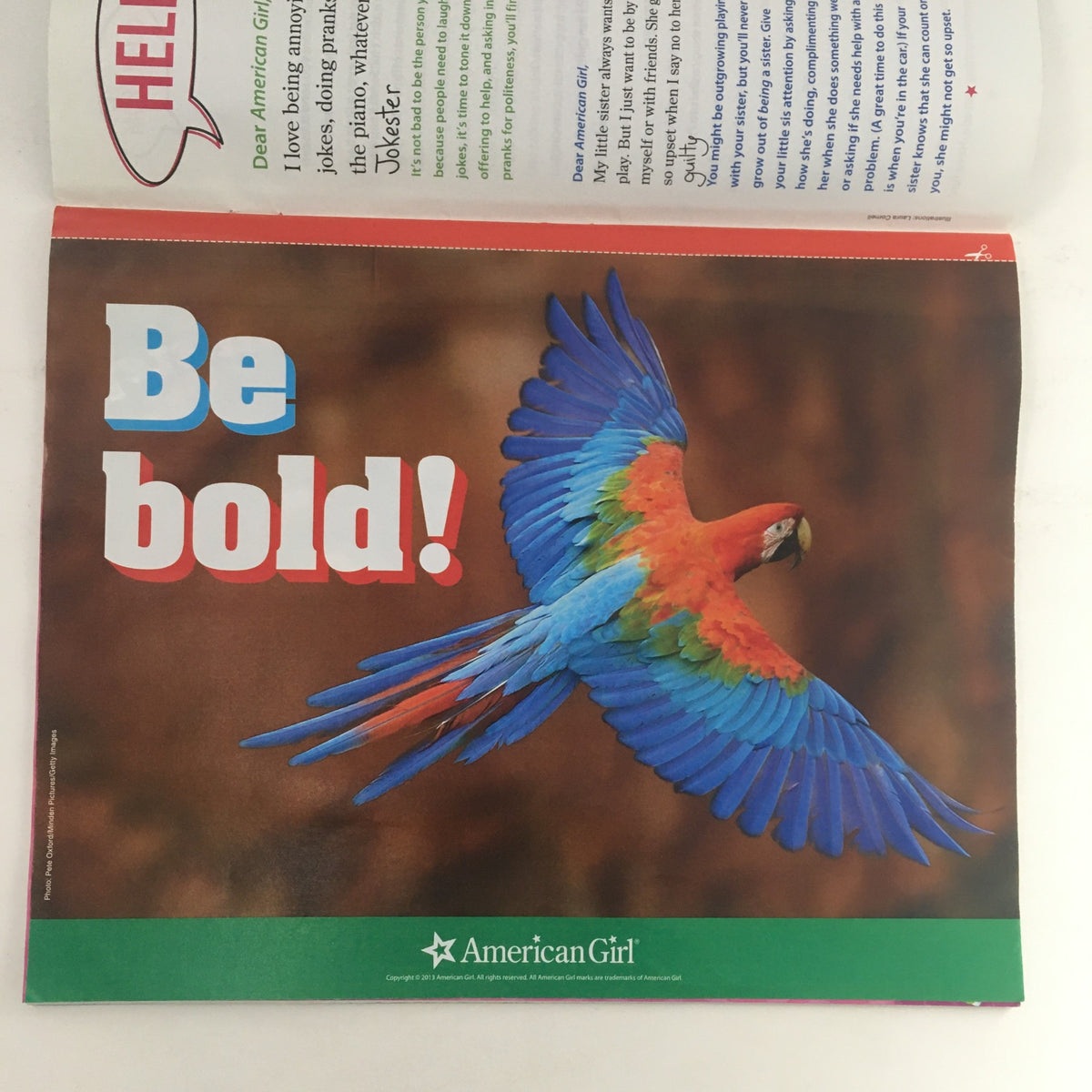 Advertisement page from American Girl Magazine May 2013 showcasing a vibrant parrot with the tagline 'Be bold!', promoting creativity and self-expression.