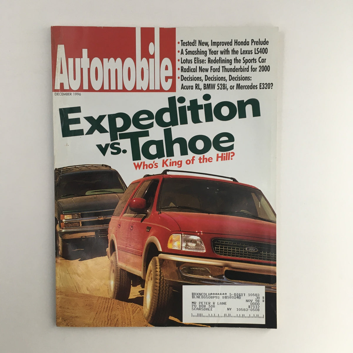 Cover of Automobile Magazine December 1996 featuring a comparison of Ford Expedition vs Chevrolet Tahoe, with the headline 'Who's King of the Hill?' showcasing two SUVs in off-road conditions.