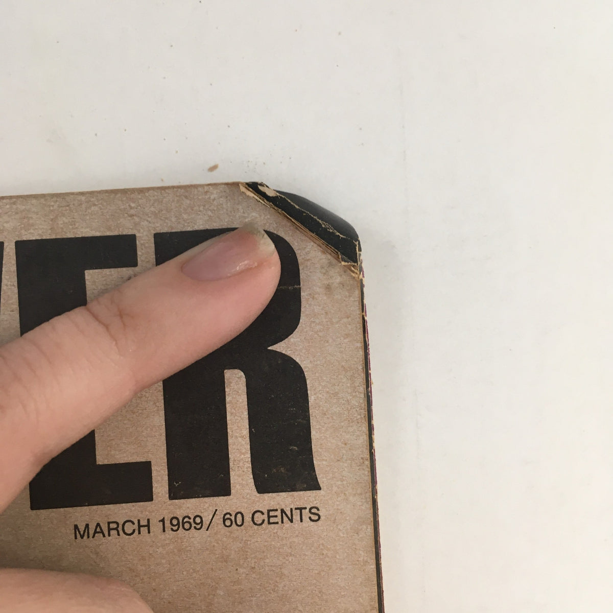 Close-up view of the corner of Car and Driver Magazine March 1969 showing a minor damage with a finger pointing at it.