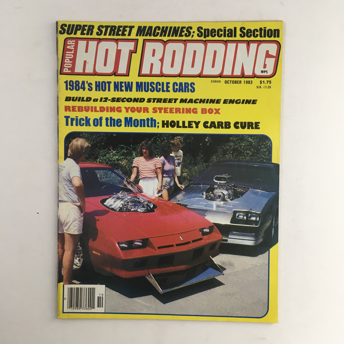 Cover of Popular Hot Rodding Magazine, October 1983 edition, featuring the 'Holley Carb Cure Trick' and showcasing a red muscle car with an open engine and a silver car in the background, highlighting automotive innovation and muscle car culture.