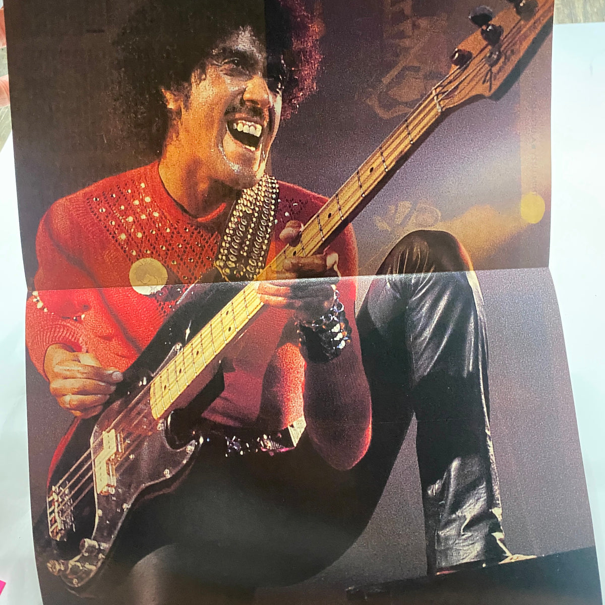 Fold-out poster featuring a live performance of a bassist from the band Thin Lizzy, included in Guitar for the Practicing Musician Magazine March 1991, showcasing the band’s vibrant stage presence.