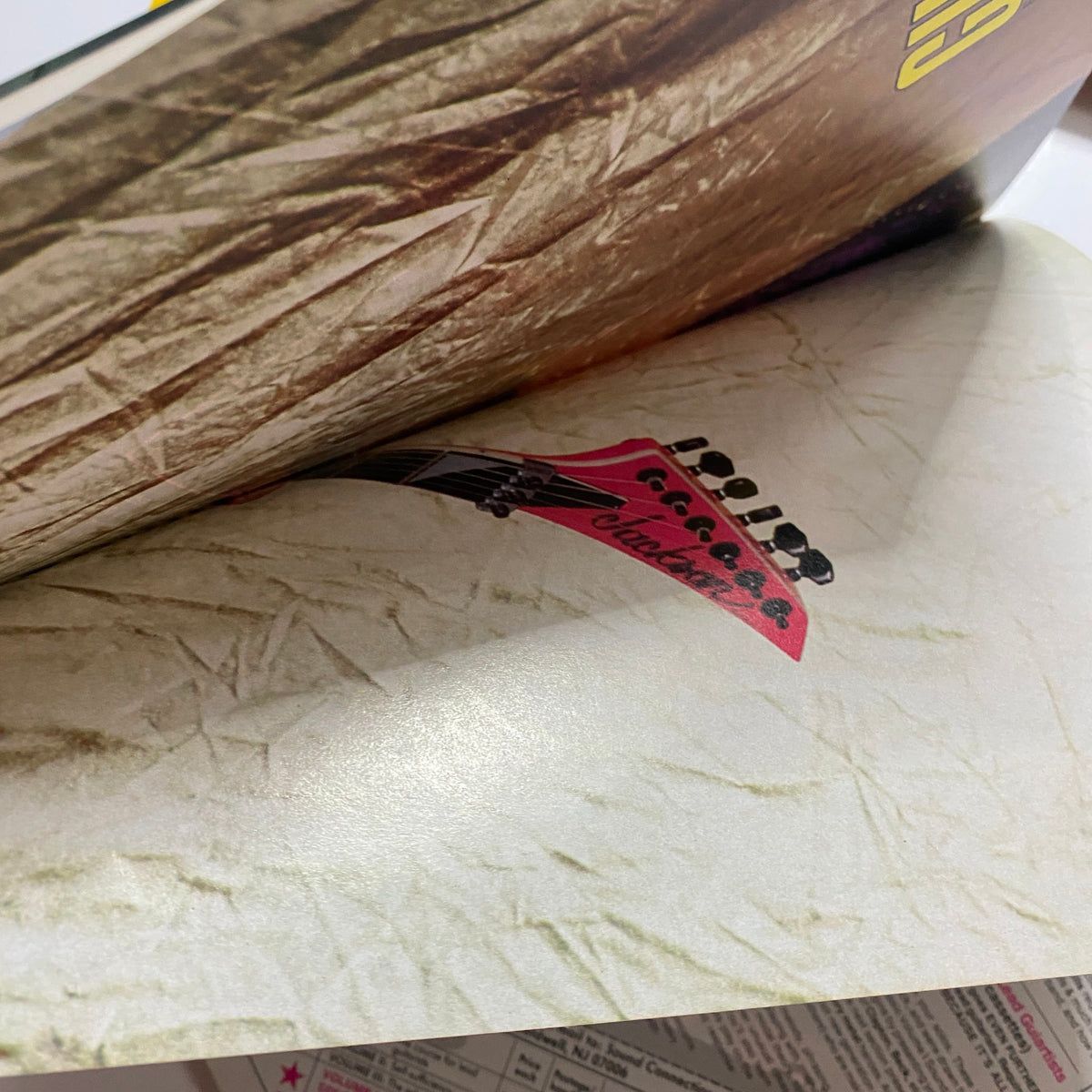 Inside spread of the Guitar for the Practicing Musician Magazine May 1987 displaying a close-up of a guitar headstock with the magazine's vibrant graphics.
