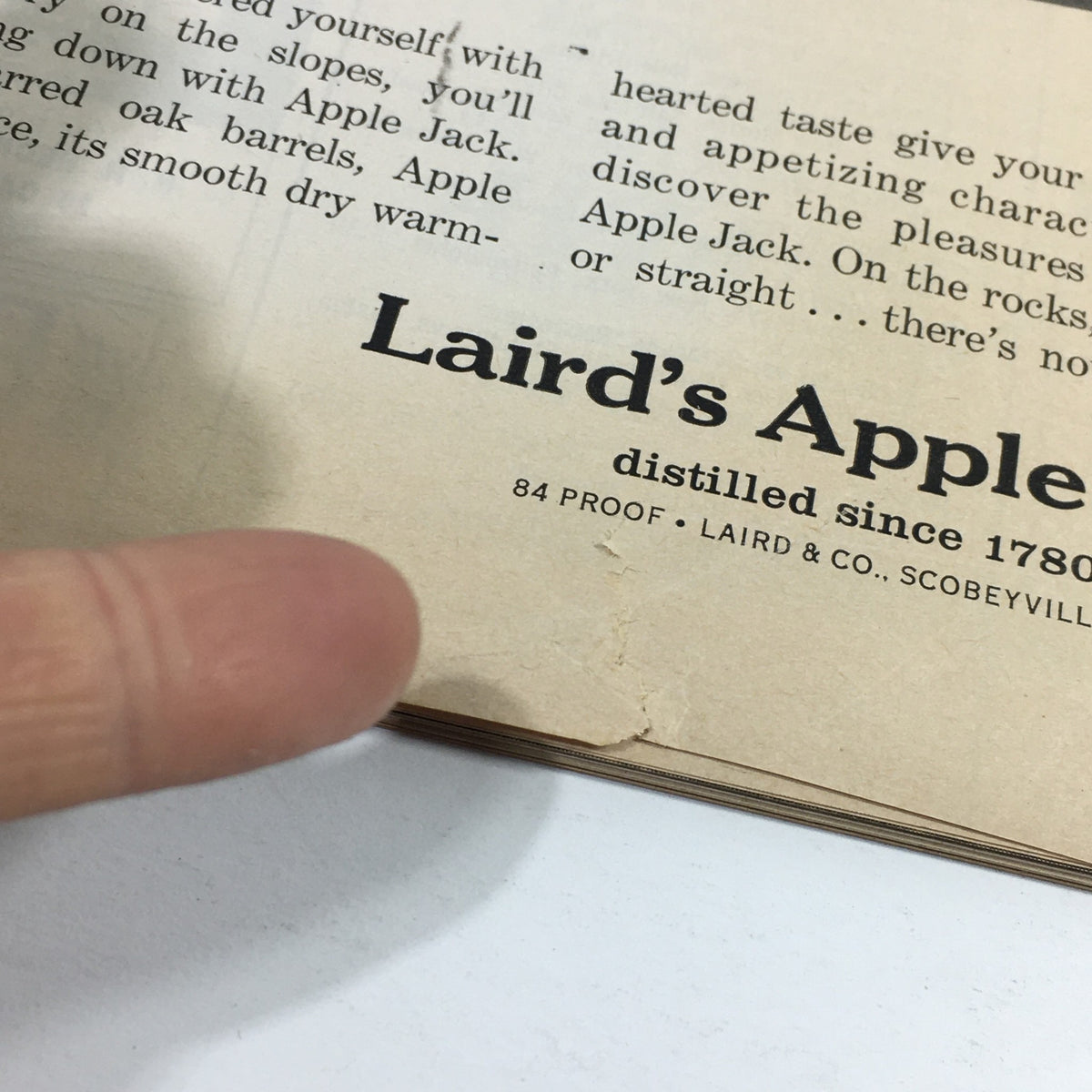 Close-up of the interior page of a vintage Sports Illustrated Magazine from January 14, 1957, featuring Laird's Apple Jack advertisement, highlighting its distillation since 1780.