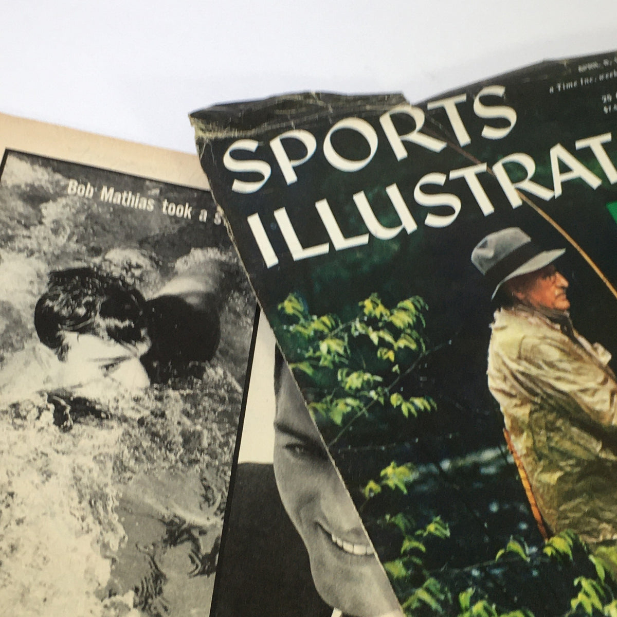Top view of the April 8, 1957 Sports Illustrated magazine, showing images of Bob Mathias swimming and people engaged in outdoor activities. The magazine's condition reflects its vintage nature, with notable wear.
