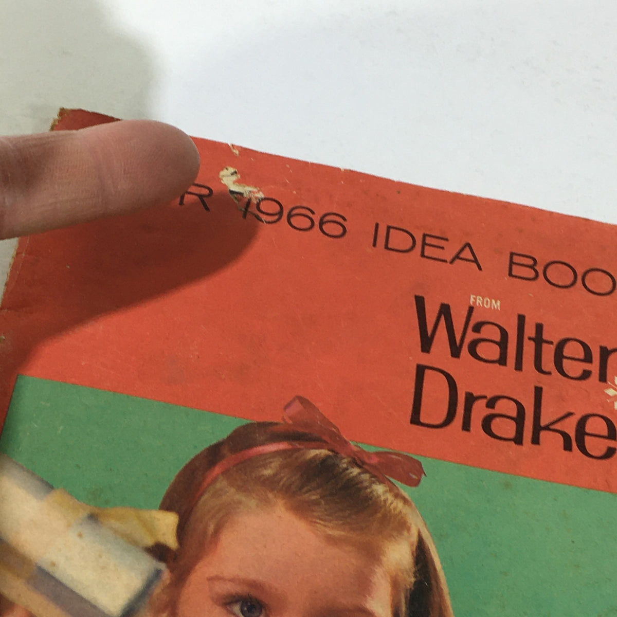 Close-up of the cover of the VTG Rare Walter Drake Idea Book For Christmas Price Guide Catalog December 1966, highlighting the title and the girl with gifts.