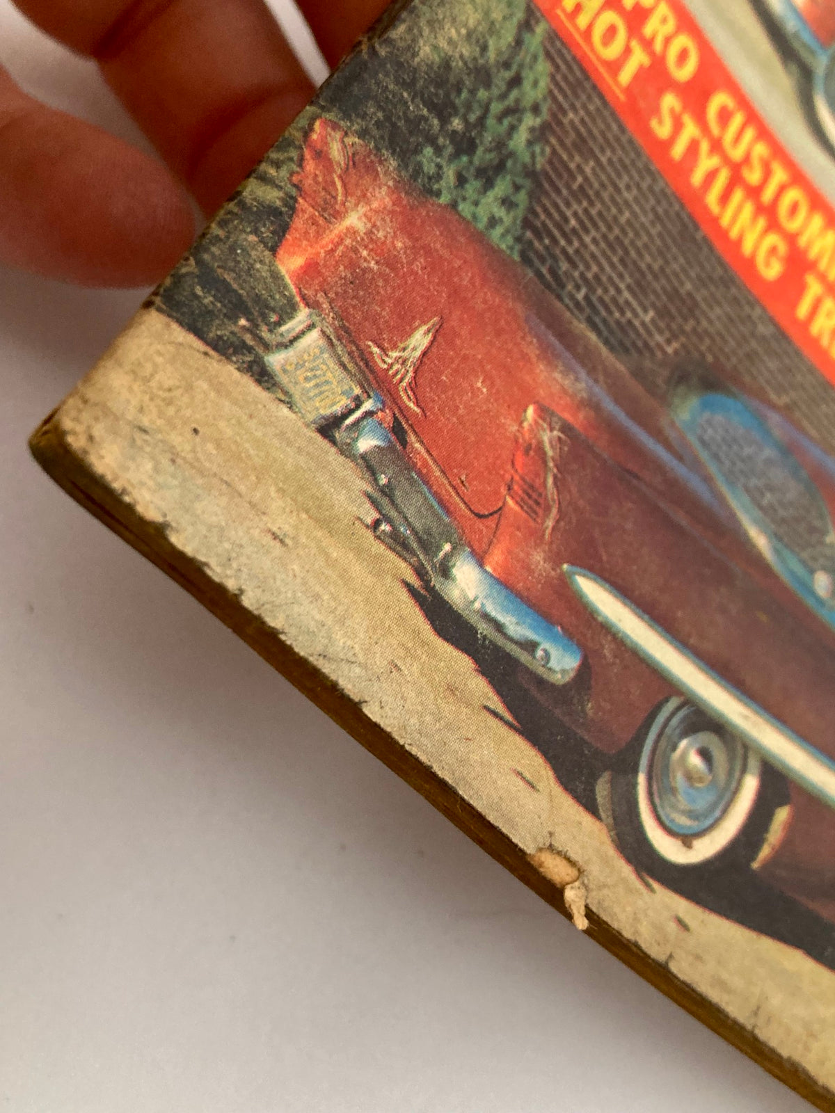 Close-up of the edge of the VTG Car Speed & Style Magazine February 1959, highlighting the vintage illustration of a classic 1953 Chevrolet. The image showcases the condition of the magazine cover with visible wear and damage, ideal for collectors and enthusiasts of vintage automotive publications.