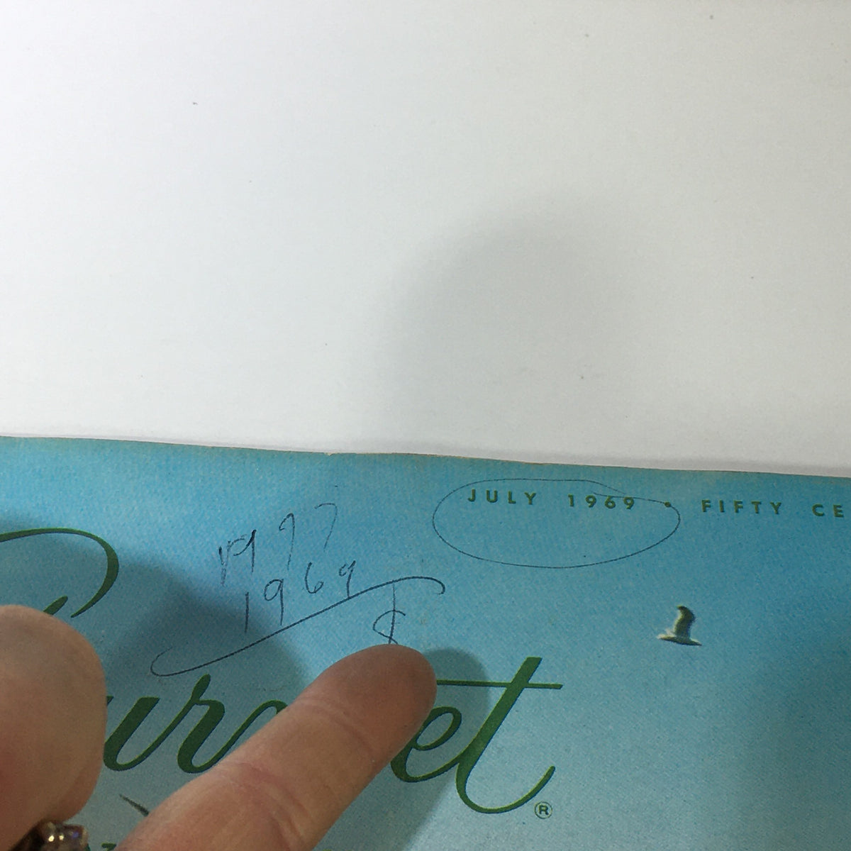 Close-up of the cover of VTG Gourmet: The Magazine of Good Living July 1969, showcasing the title and handwritten notes with the publication date.