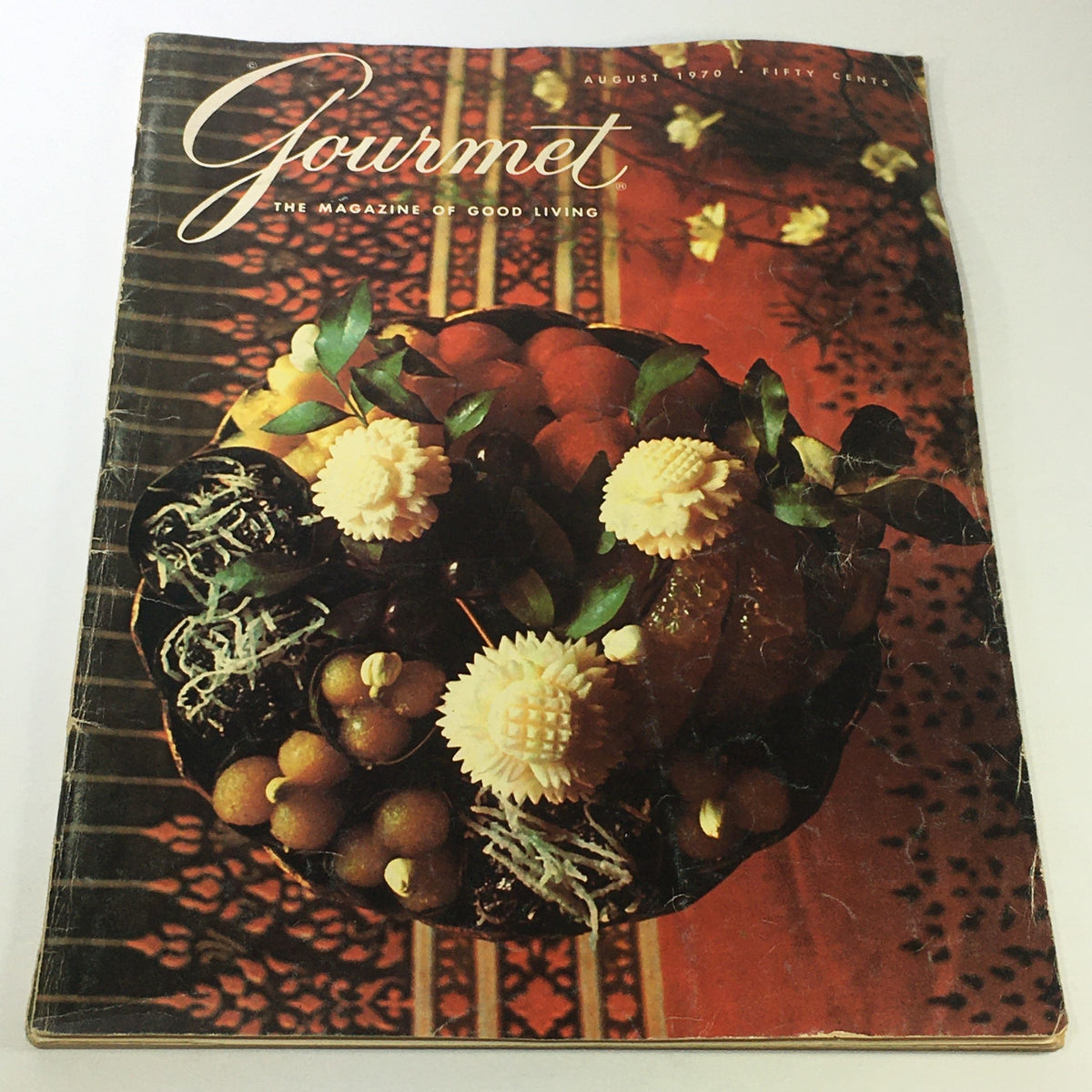 Cover of VTG Gourmet The Magazine of Good Living August 1970 featuring decorative food arrangement on a red fabric backdrop.