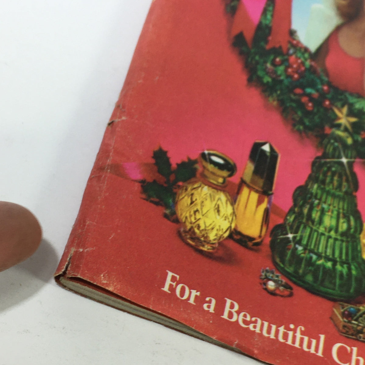 Close-up of the VTG Avon Christmas Price Guide Product Catalog December 1974, showcasing decorative Avon products including a green glass Christmas tree.