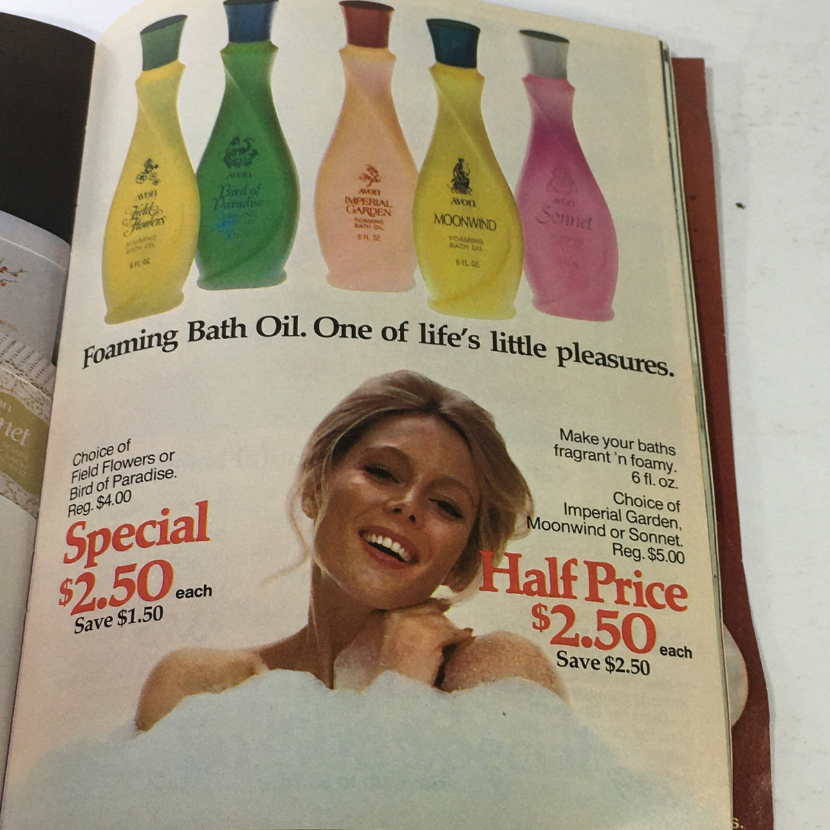 Vintage Avon Christmas Price Guide Product Catalog December 1974 highlighting Foaming Bath Oils with a smiling model.