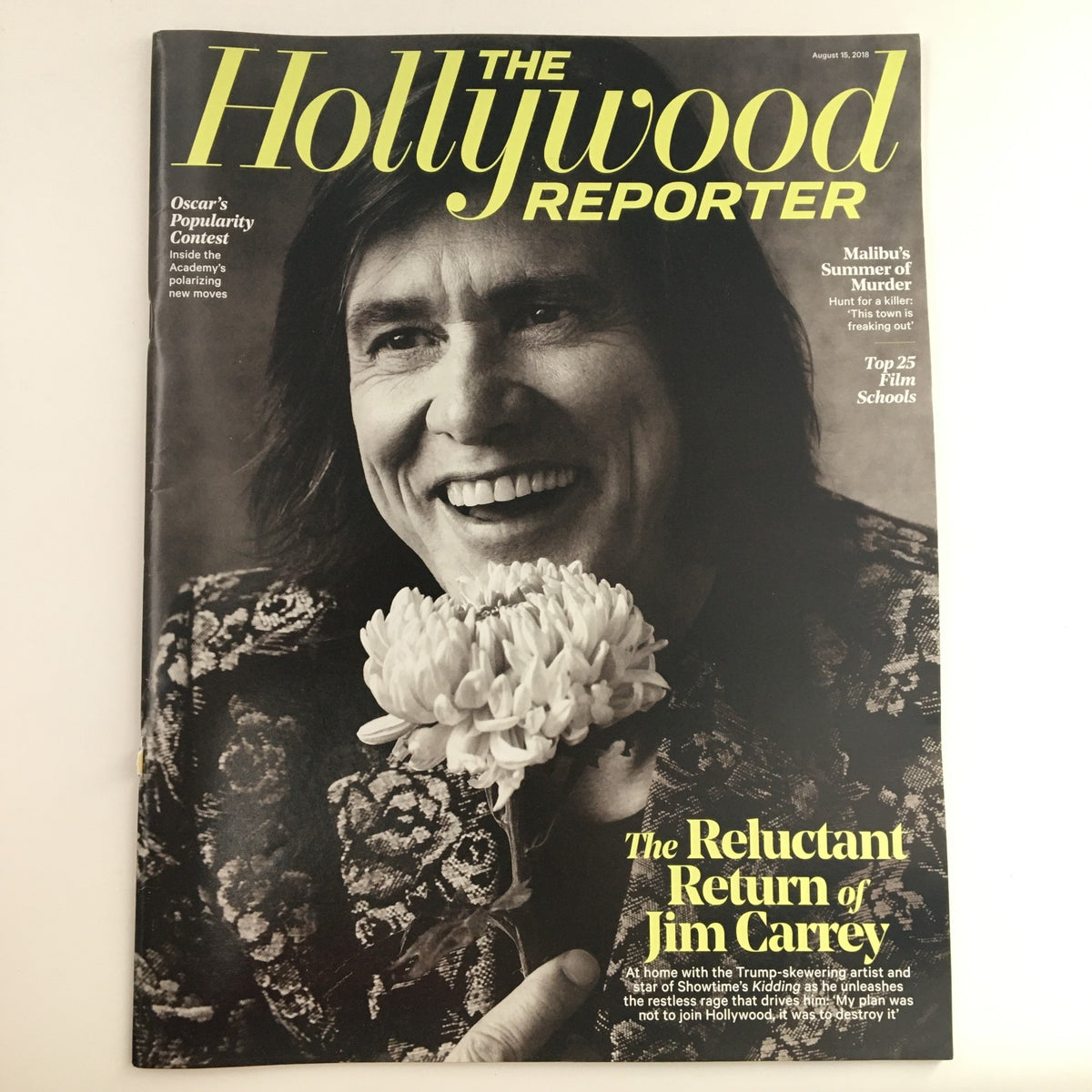 Cover of The Hollywood Reporter dated August 15, 2018, featuring Jim Carrey and titled 'The Reluctant Return of Jim Carrey'. The cover showcases Carrey smiling with a flower, highlighting his return to the entertainment spotlight.