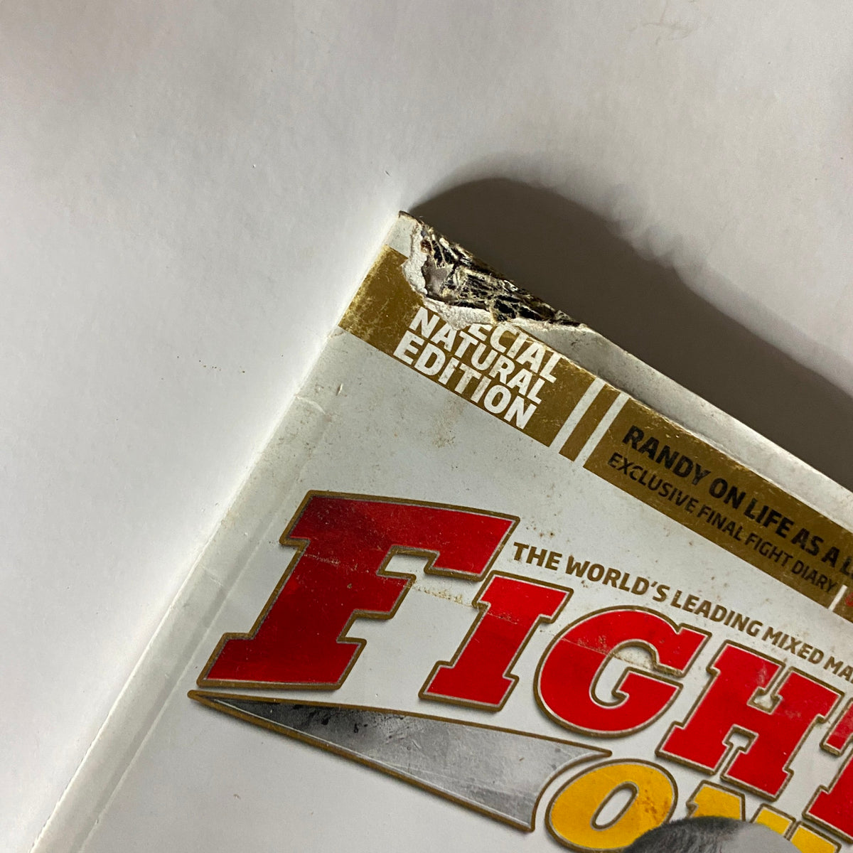 Close-up view of the top corner of Fighters Only US Magazine August 2011, highlighting signs of age and wear, specifically the Natural Edition label.
