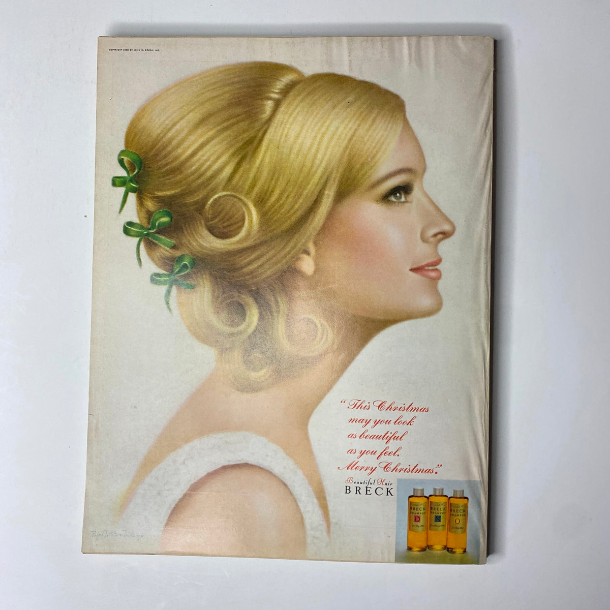 Back cover of Vogue Magazine December 1967, featuring a vintage Christmas advertisement for Breck hair products, showcasing a model with elegant hairstyle.