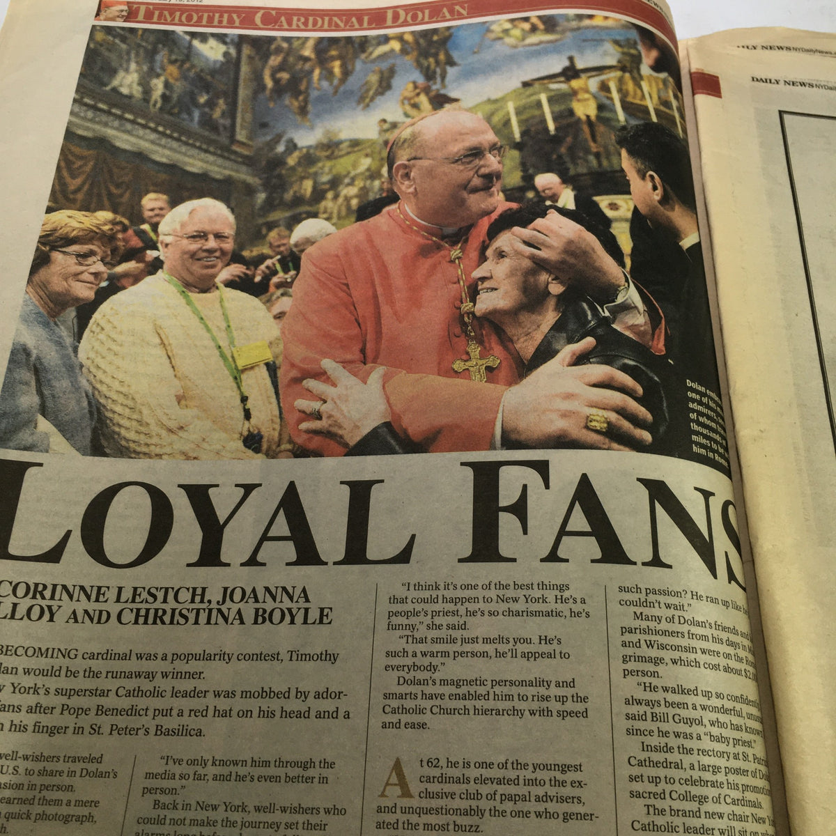 Image from New York Daily News February 19 2012 showing Timothy Cardinal Dolan embracing loyal fans in celebration, illustrating the emotional connection he shares with the public.