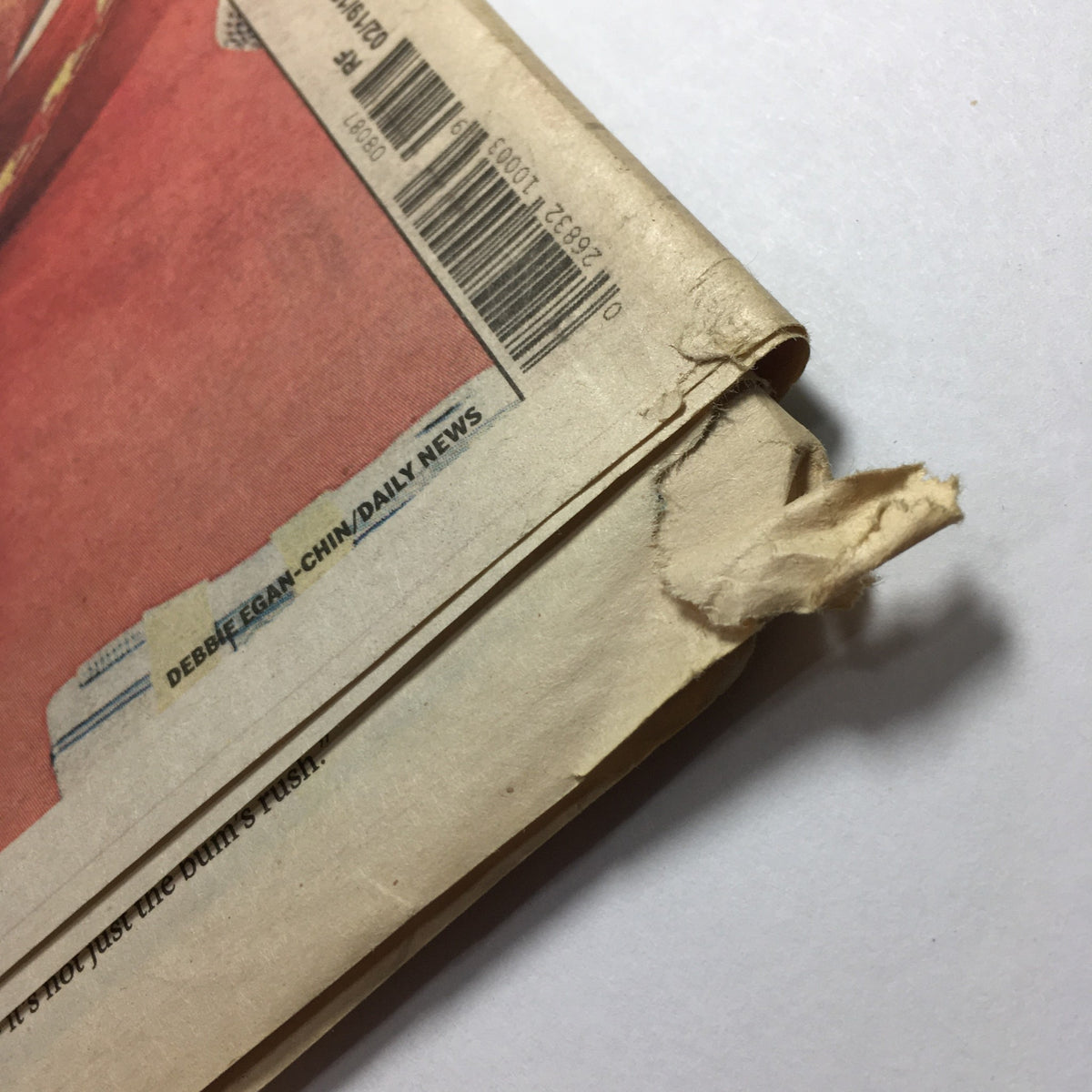 Close-up of the edge of the New York Daily News February 19 2012, showing minor wear and tear, indicating its vintage status and history.