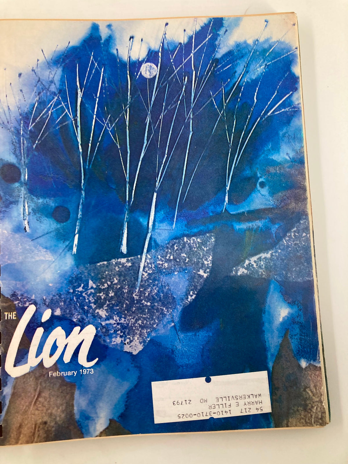 Cover of The Lion Magazine February 1973 showcasing a serene watercolor depiction of bare trees against a blue night sky with a full moon.
