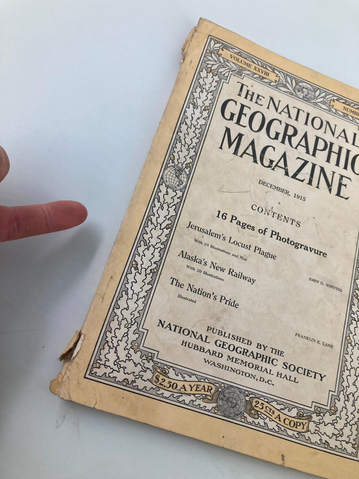 Close-up view of the cover of December 1915 National Geographic Magazine, highlighting the article 'Alaska's New Railway' and showing minor wear.