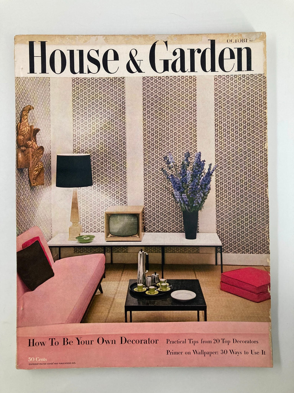 Cover of VTG House & Garden Magazine from October 1954 featuring mid-century decor, titled 'How To Be Your Own Decorator'. The cover showcases a stylish living room with a pink sofa, vintage television, and decorative elements.