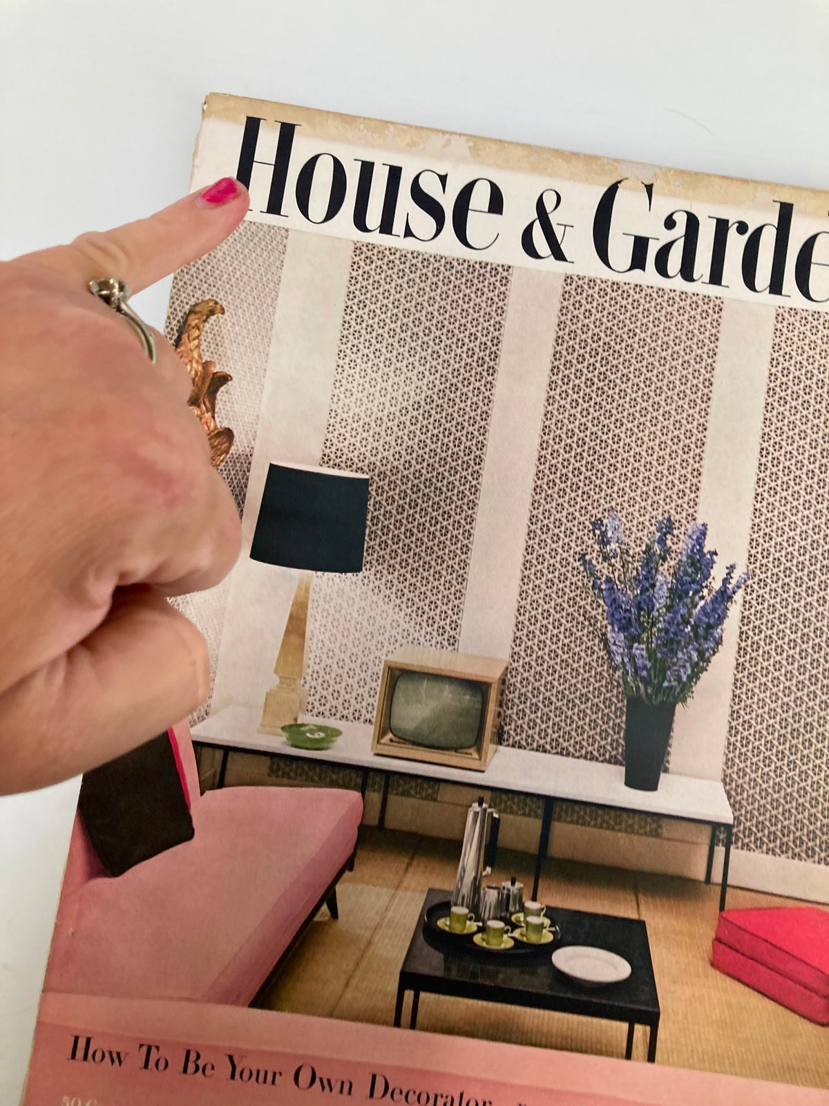 Detail of the cover of VTG House & Garden Magazine from October 1954, focusing on the title 'House & Garden'. Highlights the mid-century design elements alongside a decorative figure and floral arrangement.