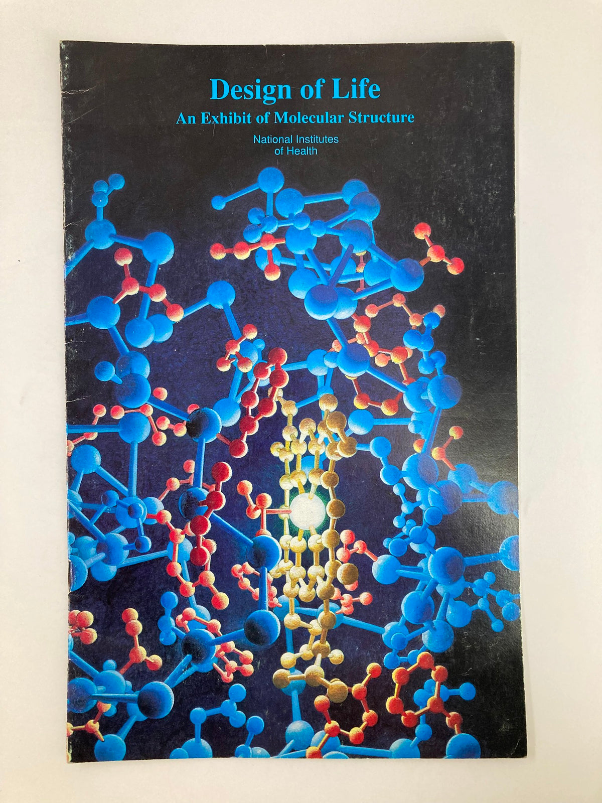 Cover of 'Design of Life: An Exhibit of Molecular Structure' at the National Institutes of Health, featuring colorful molecular structures.