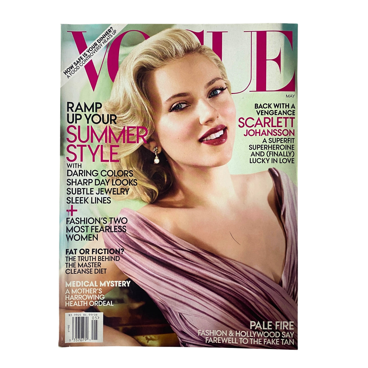 Vogue Magazine cover from May 2012 featuring Scarlett Johansson, styled in a silk plissé-pleat dress from Prada and adorned with Van Cleef & Arpels earrings. This issue showcases Johansson's captivating look and highlights her interview discussing her career and personal life.
