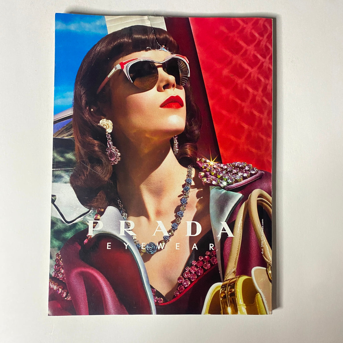 Vogue Magazine June 2012 featuring a Prada eyewear advertisement showcasing a glamorous model with stylish accessories. The vibrant colors and chic design highlight the luxury fashion appeal.