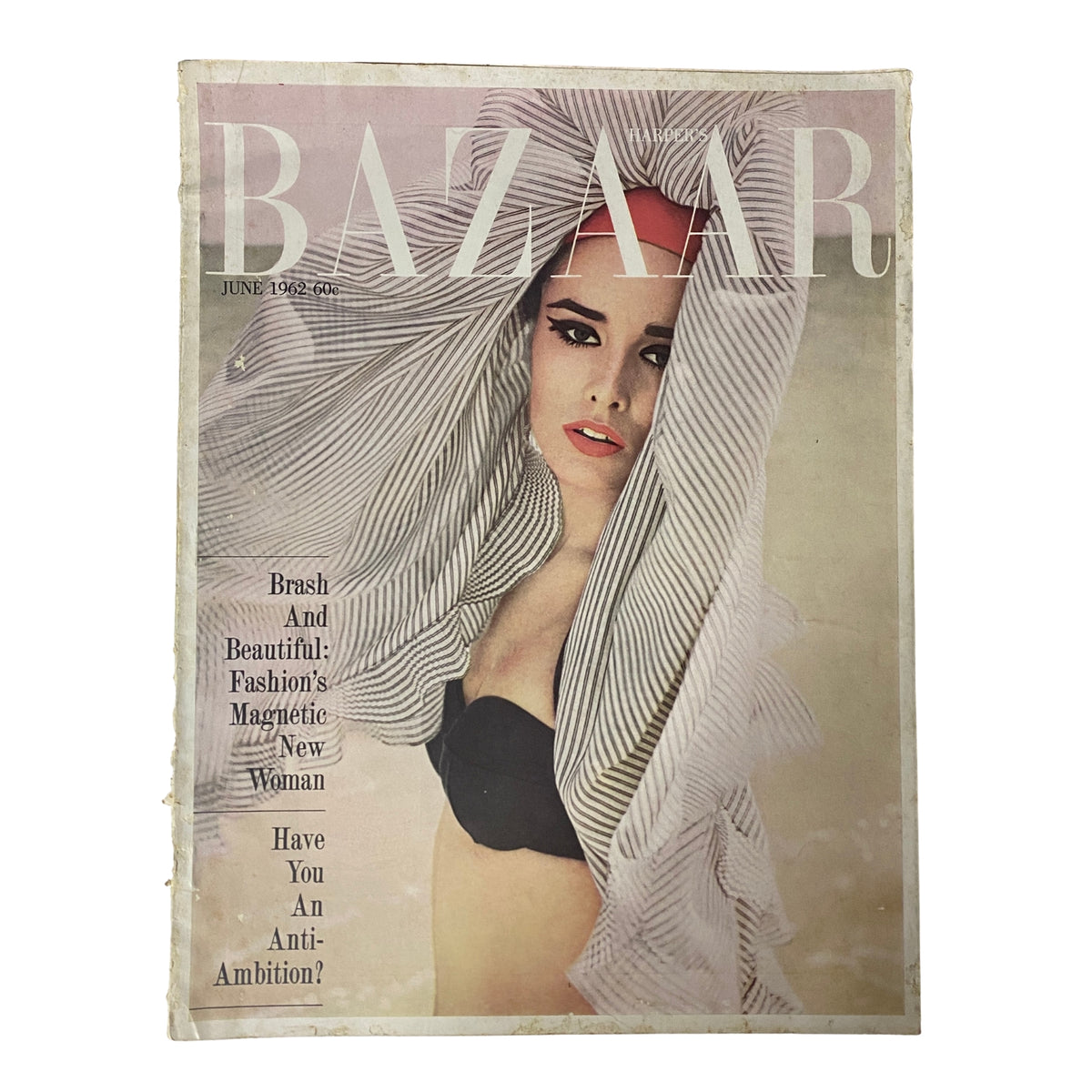 Harper's Bazaar Magazine June 1962 featuring the cover 'Brash And Beautiful! Fashion's Magnetic New Woman'. Displays a model with striking makeup, wearing a bikini and a stylish head wrap, capturing the vibrant summer fashion essence of the 1960s.