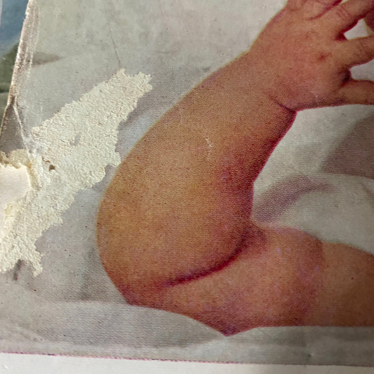Close-up of a baby's arm featured in an advertisement within Harper's Bazaar Magazine June 1961.