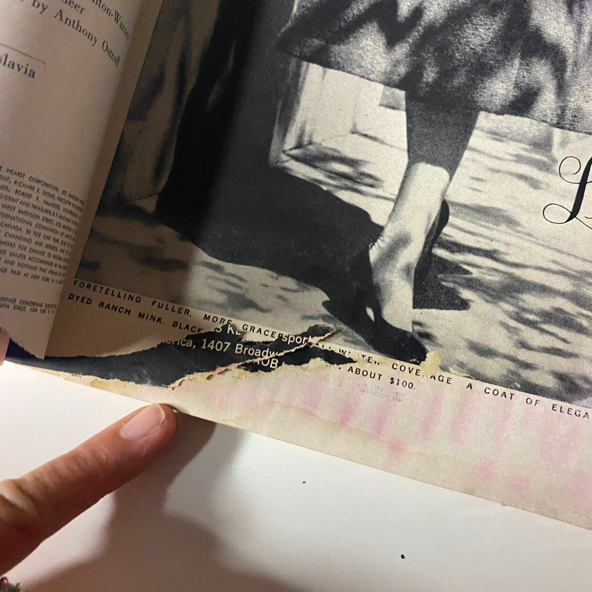 A close-up of Harper's Bazaar Magazine August 1960 highlighting a damaged page corner, yet showcasing the vintage design and text related to fashion features and advertisements of the era.