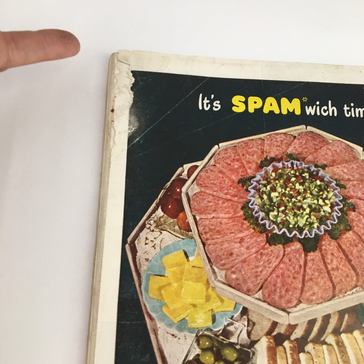 Back cover of a vintage magazine promoting Spam sandwiches, showcasing an appetizing platter, emphasizing a playful theme.