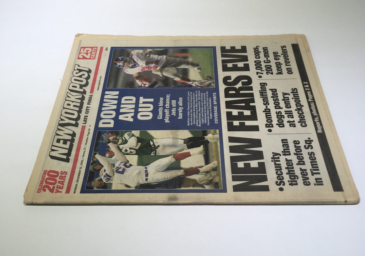 Cover of NY Post from 12/31/2001 featuring the headline 'Down and Out' detailing how the Giants blew their playoff chances while the Jets remain barely alive. The image showcases sports players in action, emphasizing the dramatic moments of the game.