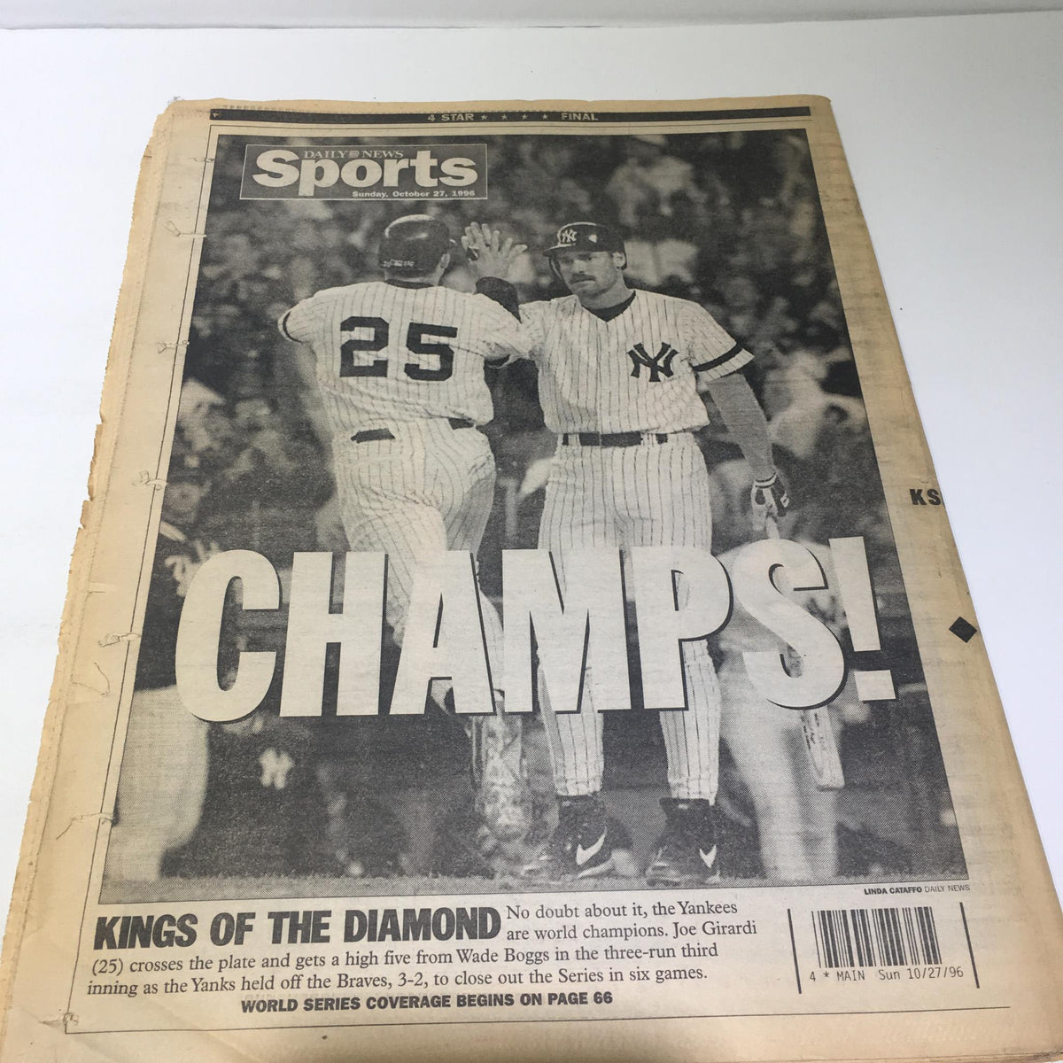 New York Daily News sports page titled 'CHAMPS!' capturing Yankees players celebrating after their World Series win.