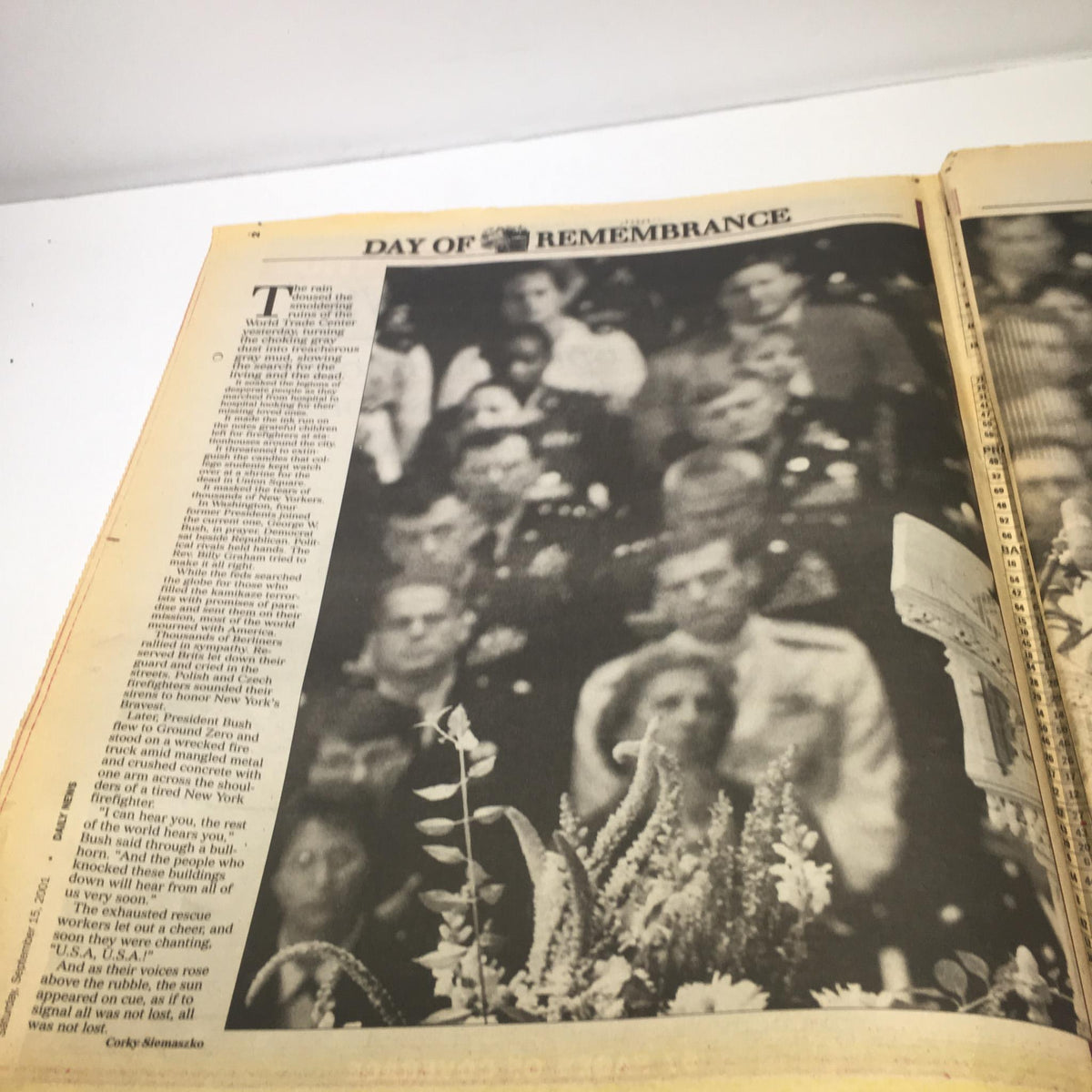 New York Daily 911 President George W Bush Rememberence Special edition. Interior page titled 'DAY OF REMEMBRANCE' with a black and white photograph of attendees at a memorial event, illustrating the somber atmosphere.
