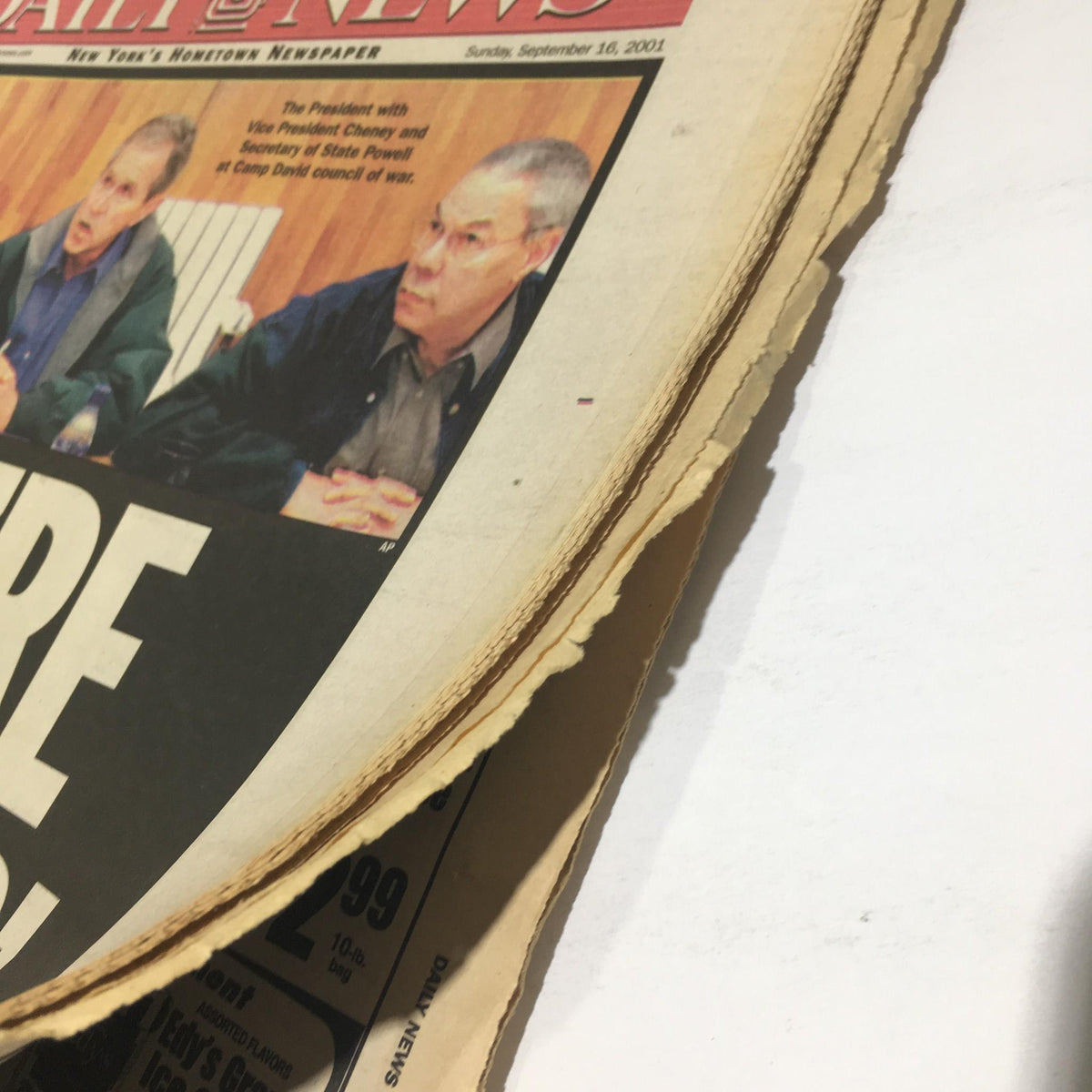 Side view of the New York Daily News from September 16, 2001, featuring the headline 'WE'RE AT WAR' and the edge of the newspaper showing wear from age.