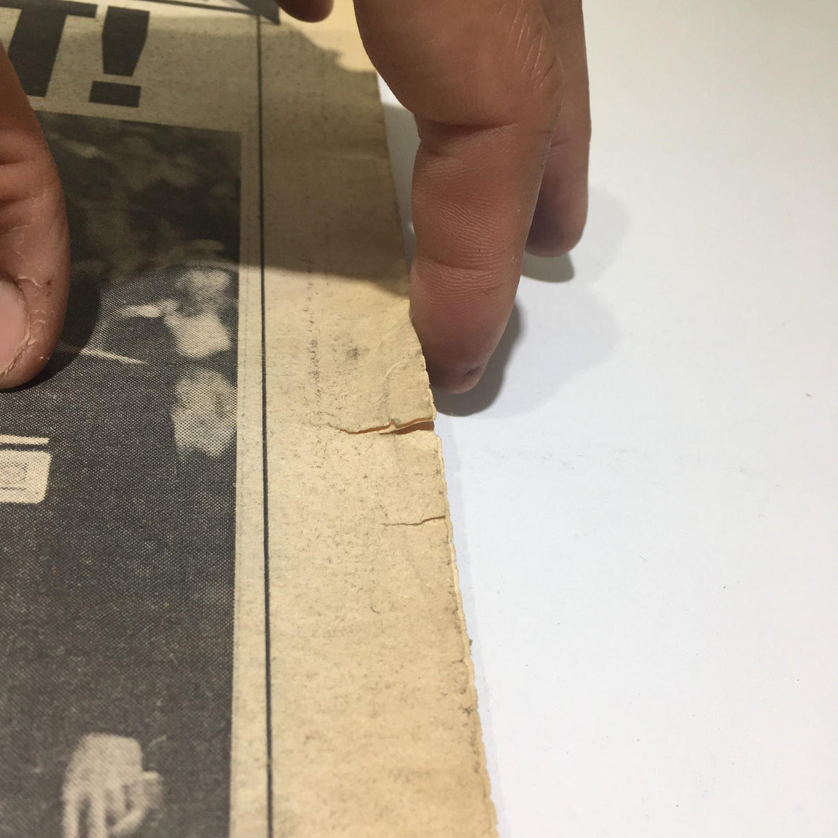 Image showing a hand pointing at a tear on the edge of the NY Daily News from October 28, 1986, which documents the Mets' World Series triumph over the Red Sox.