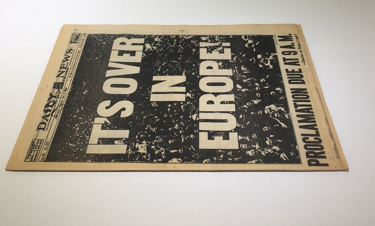 Back view of the New York Daily News May 8, 1945, newspaper showing the headline 'IT'S OVER IN EUROPE!' and the proclamation details due at 9 A.M., significant in WWII history.