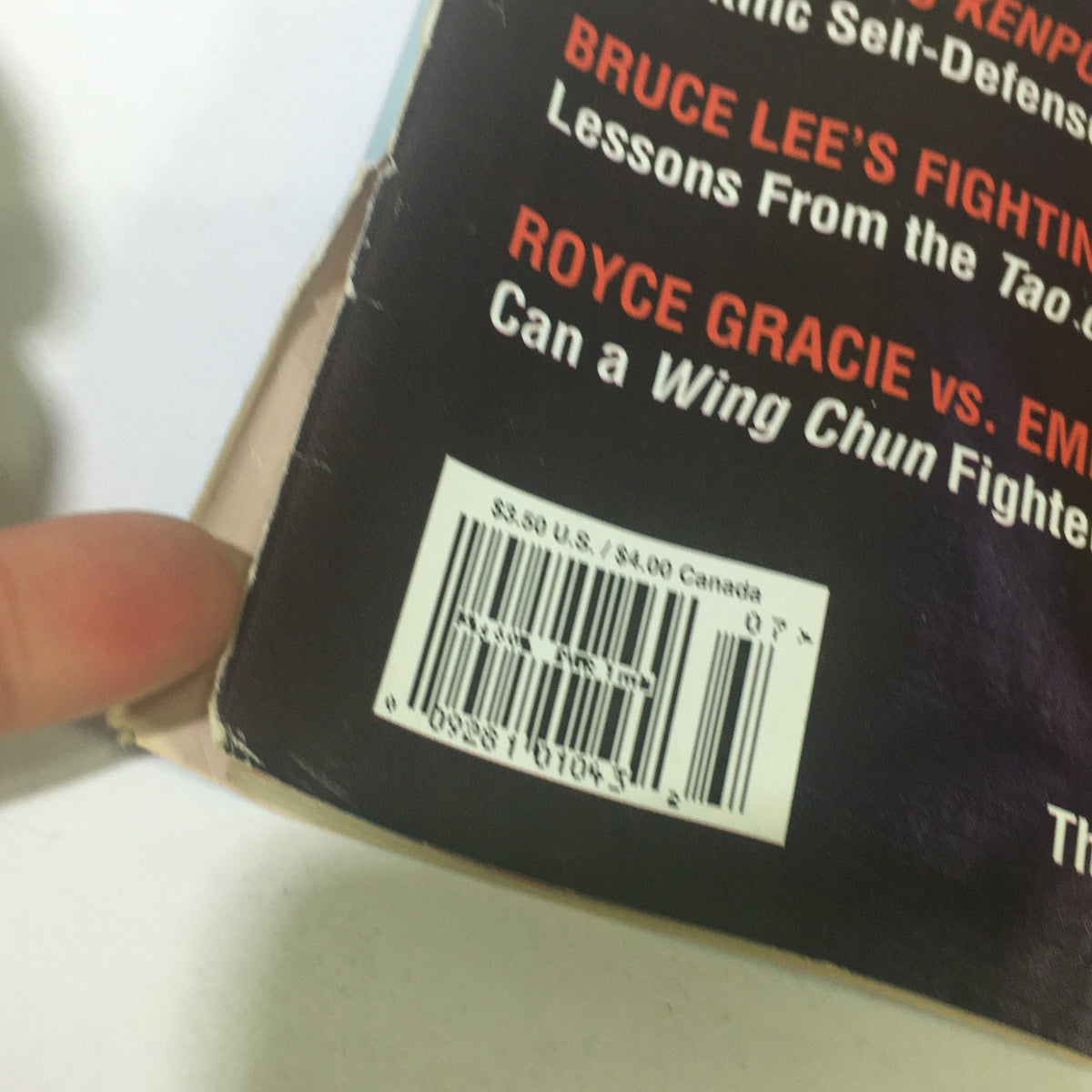 Close-up of the back cover of Black Belt Magazine July 1995, showcasing the printed barcode and articles including Bruce Lee's fighting secrets and Royce Gracie vs Emin Boztepe.