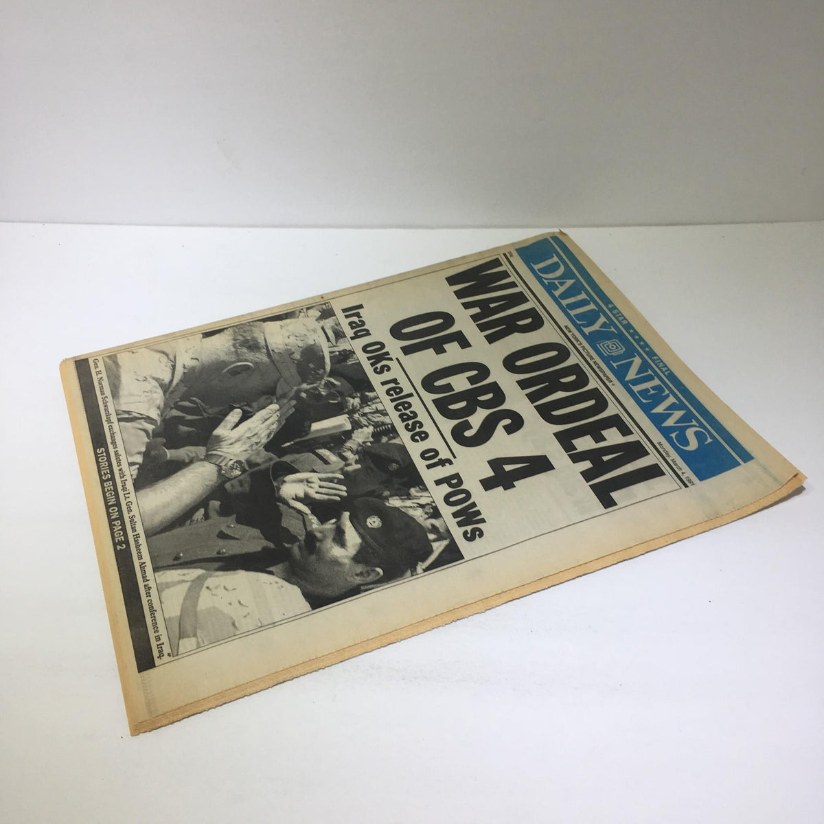 The front page of a vintage newspaper with the headline 'War Ordeal of CBS 4,' detailing the release of POWs by Iraq. The newspaper dates back to March 4, 1991, showcasing the events of the Gulf War.