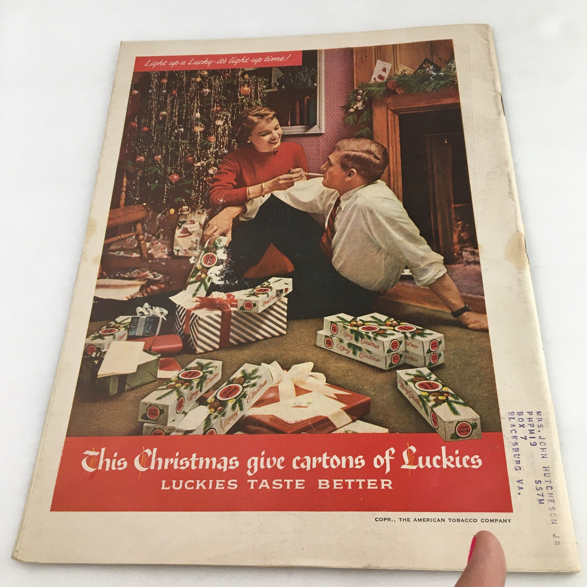 Cover of Town Journal Magazine December 1955 featuring a Christmas scene with a man and woman surrounded by gifts and a decorated tree, emphasizing the holiday spirit and the tagline 'This Christmas give cartons of Luckies, Luckies taste better.'