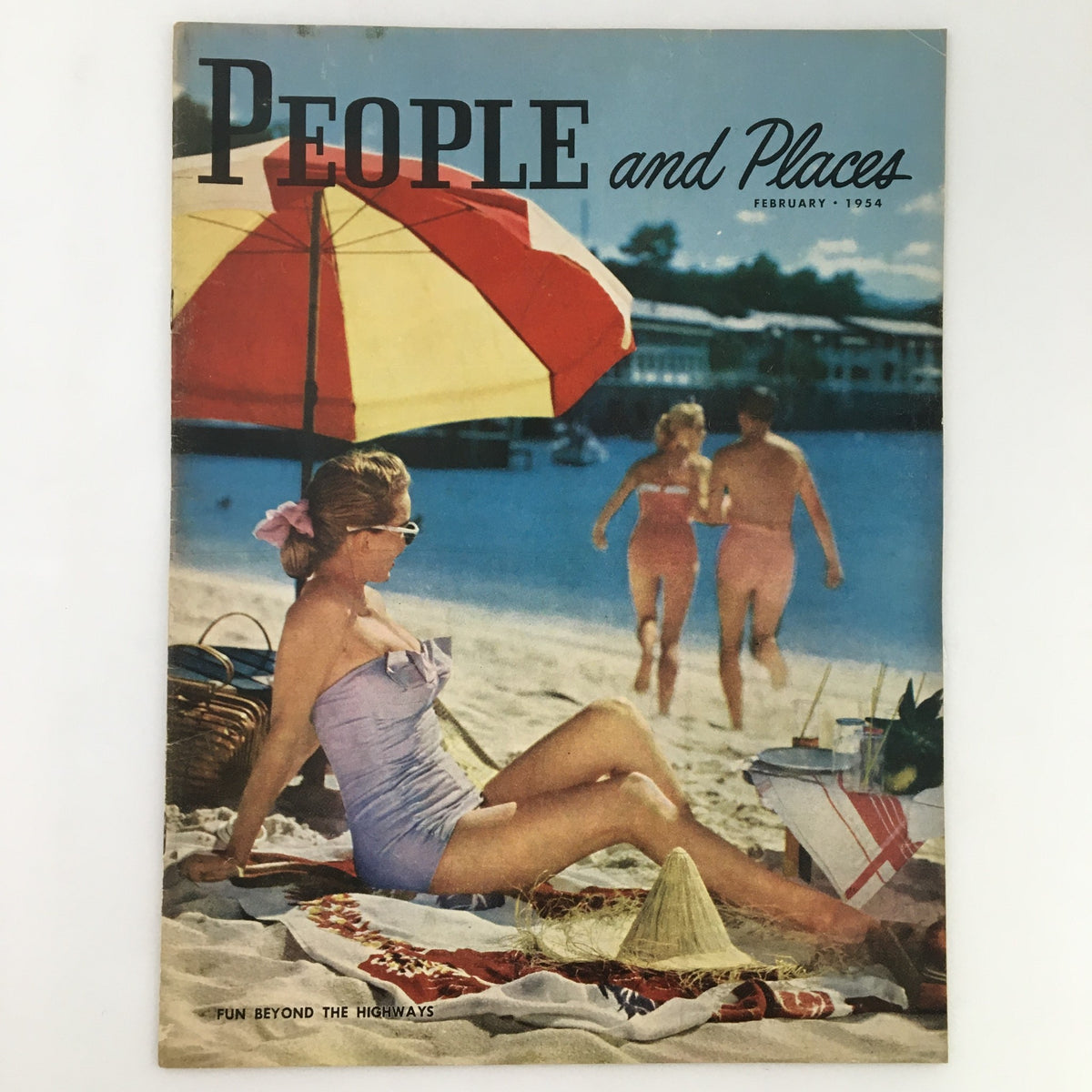 Cover of People and Places Magazine February 1954 featuring a beach scene with a woman in a swimsuit relaxing under an umbrella, embodying the theme 'Fun Beyond the Highways'.