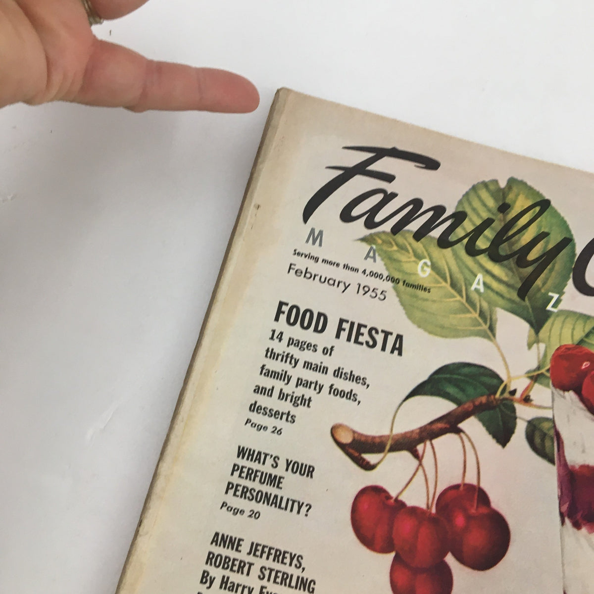 Close-up of the Family Circle Magazine February 1955 cover showcasing food fiesta headlines and vibrant cherry dessert imagery.