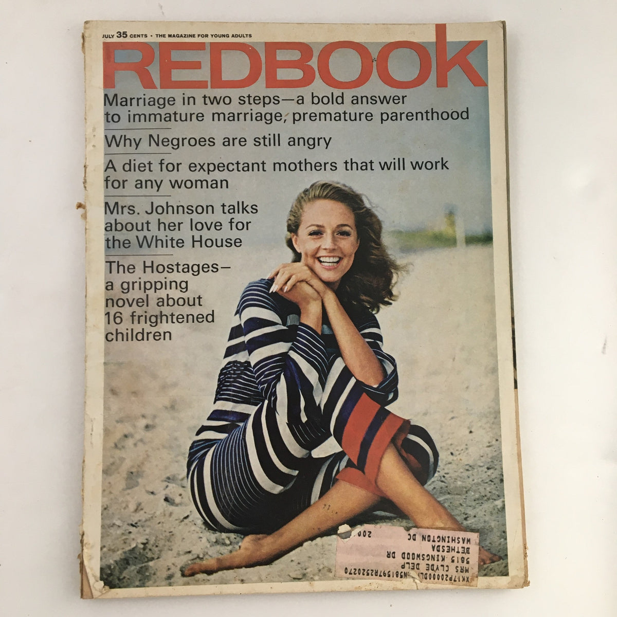 Cover of Redbook Magazine July 1966 featuring the article 'Mrs. Johnson Talks About Her Love for the White House', showcasing a woman in a striped outfit sitting on a beach.