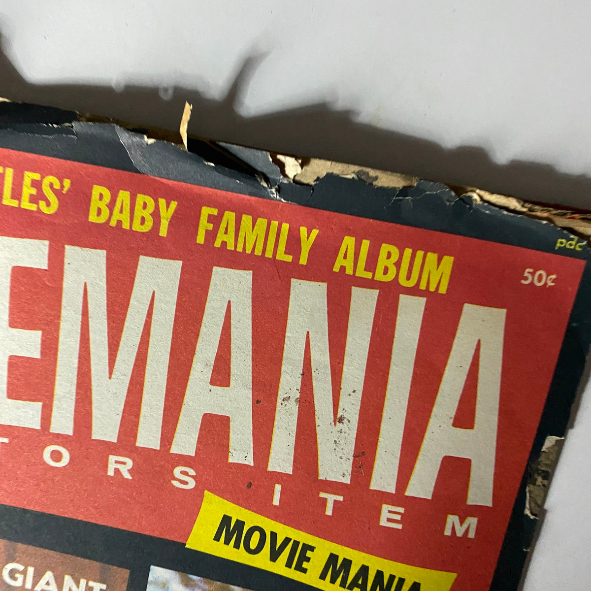 Close-up of the vintage Beatlemania magazine cover from 1964, highlighting the title 'BEATLEMANIA' with vibrant red and yellow colors.
