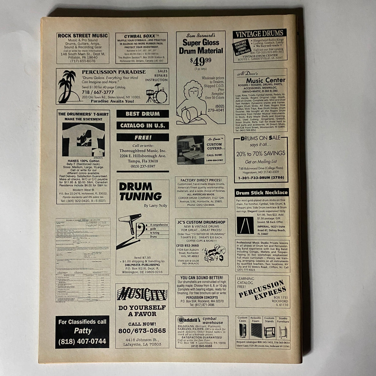 Back cover of Rhythm Total Percussion Magazine December 1989 highlighting advertisements related to drumming equipment and music services from that era.