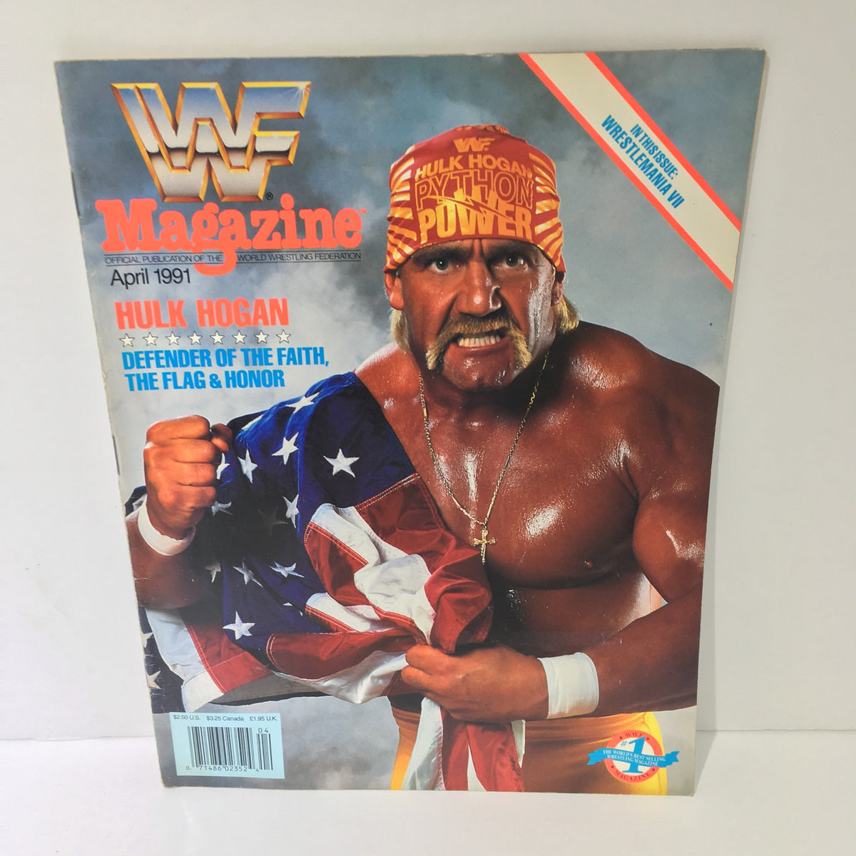 WWF Magazine featuring Hulk Hogan on the cover, titled 'Defender of Faith, Flag & Honor' from April 1991, showcasing Hogan flexing his muscles while holding an American flag, symbolizing patriotism and strength in wrestling.
