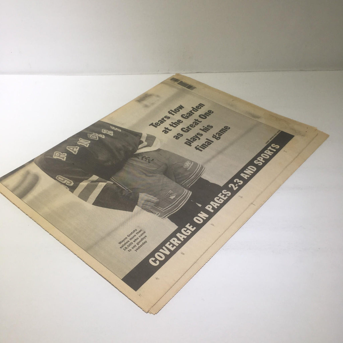 Angled view of a vintage NY Daily News newspaper from 4/19/99, highlighting the coverage of Wayne Gretzky's farewell with text describing emotional moments at the Garden.