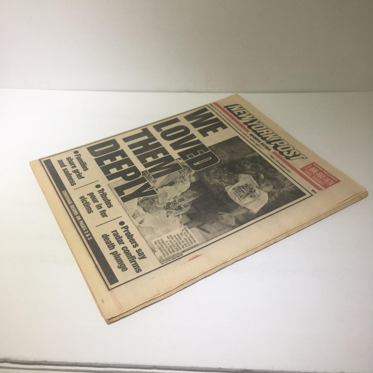 Side angle view of NY Post featuring the headline 'WE LOVED THEM DEEPLY', showcasing the newspaper's significance in reporting on heartfelt tributes.